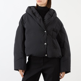 Model wearing Max Mara Sportmax black cropped puffer jacket with lapel collar, snap buttons, and wide sleeves, styled with black trousers
