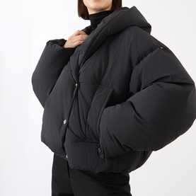 Model wearing Max Mara Sportmax black cropped puffer jacket with hood, styled with black turtleneck