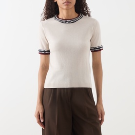 Model wearing Max Mara S Carina Contrast Trim Sweater in albino with black and red contrast trim at neckline and cuffs, styled with brown wide-leg