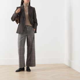 Model wearing Max Mara S Clay Melange wool knit, styled with grey check trousers, dark blazer, and black loafers