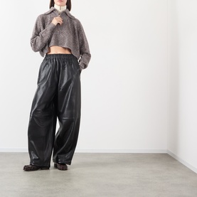 Model wearing Max Mara Sportmax rust bl wool cashmere cropped knit top, styled with black wide-leg leather trousers and dark loafers.