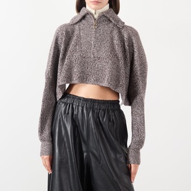 Model wearing Max Mara Sportmax rust bl wool cashmere cropped half-zip knit top, styled with black leather wide-leg trousers.