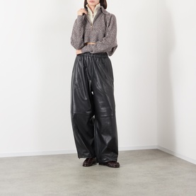 Model wearing Max Mara Sportmax rust bl wool cashmere knit crop top, styled with black wide-leg leather trousers and dark ankle boots.