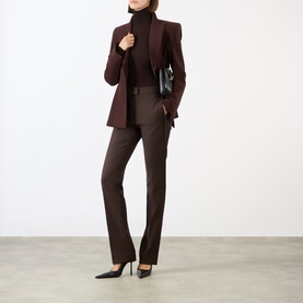 Model wearing Max Mara Sportmax chocolate wool turtleneck top, styled with matching brown suit and black heels, carrying small black bag.