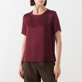 Model wearing Max Mara S Rebecca Solid T-Shirt in bordeaux; crew neck, short sleeves, smooth finish, styled with khaki trousers.