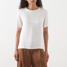 Model wearing Max Mara S ivory short-sleeve top in acetate-viscose blend, styled with brown wide-leg trousers.