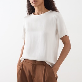 Model wearing Max Mara S ivory short-sleeve top in acetate-viscose blend, styled with tan wide-leg trousers.