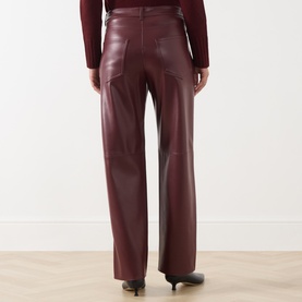 Model wearing Max Mara S Sospiro Faux Leather Straight Trousers in bordeaux, rear view, styled with a dark top and black heels.