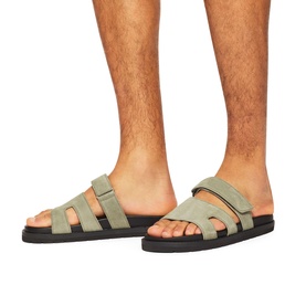 Model wearing KG by Kurt Geiger green suede strappy slides with black rubber sole