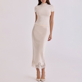 Model wearing House of CB ivory knit midi skirt with lace hem, styled with matching short-sleeve top and nude heels