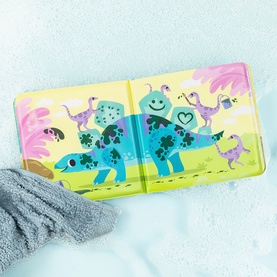 Tiger Tribe colour-changing bath book open to show blue dinosaur illustrations, pictured with a grey sponge in a wet bath setting