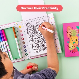 Child colouring a detailed drawing using Tiger Tribe multi colouring pens, with a bright pineapple-themed notebook alongside on a green surface.