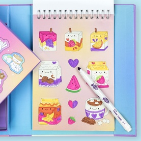 Tiger Tribe multi-coloured kawaii food and drink sticker sheet displayed on spiral notepad with Sharpie pen alongside