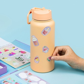 Tiger Tribe Multi Stickers being applied to a peach water bottle, with sticker sheets featuring cute characters displayed alongside