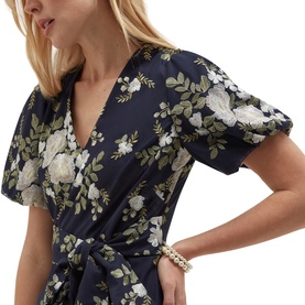Model wearing Hobbs midnight ivory floral wrap dress with puff sleeves and tie waist, styled with a gold bracelet