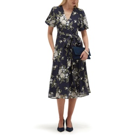 Model wearing Hobbs midnight ivory floral wrap dress with flutter sleeves and tie waist, styled with navy clutch bag and navy heels.