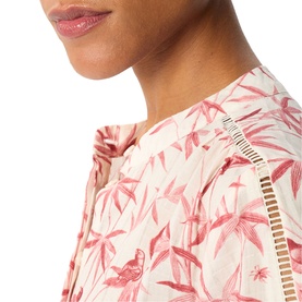 Model wearing Whistles pink floral bird print top with ruffle detail and cut-out trim, close-up shot