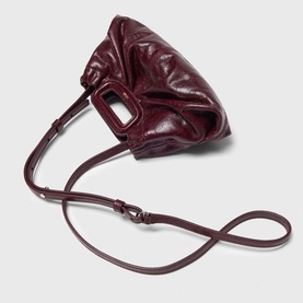 Deep burgundy crinkled leather mini bag with top handle, gunmetal hardware, and detachable crossbody strap, shown laid flat