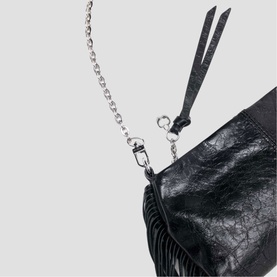 Maje black leather bag detail with silver chain strap and fringe trim close-up