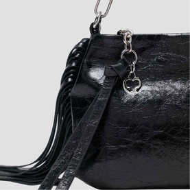 Maje bag in red patent leather with fringe tassel detail, silver chain handle and heart charm close-up