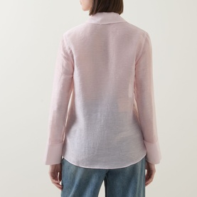 Model wearing Aligne light pink linen blend shirt, back view, styled with blue jeans