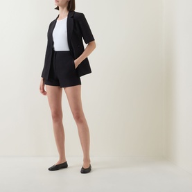 Model wearing Aligne black linen-blend mini skirt with matching blazer, white top, and black flat shoes.