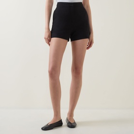 Model wearing Aligne black linen-blend mini skirt, styled with black ballet flats.