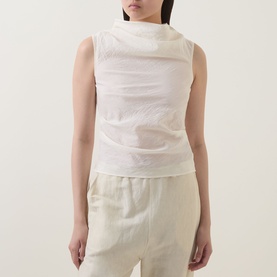 Model wearing Aligne Dana Sheer Textured Blouse in ivory, sleeveless with draped cowl neck, styled with cream wide-leg trousers.