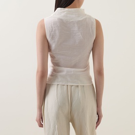 Model wearing Aligne Dana Sheer Textured Blouse in ivory, sleeveless with textured finish, styled with matching wide-leg trousers, back view.