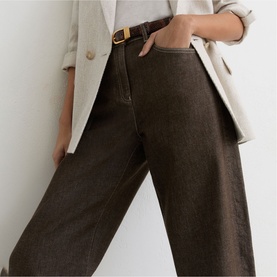 Model wearing Reiss brown wide-leg trousers with a gold buckle belt, styled with a cream blazer