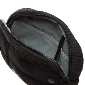 Columbia black sherpa fleece bum bag, open view showing grey zip interior lining and multiple compartments