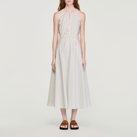 Model wearing Sandro Womens French Dress in ecru and blue stripe, midi length, sleeveless, with brown flatform sandals.