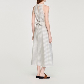 Model wearing Sandro Womens French Dress in ecru and blue stripe, back view, tie waist detail, midi length, styled with tan sandals.