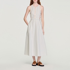Model wearing Sandro Womens French Dress in ecru and blue stripe, midi length, sleeveless, styled with tan sandals