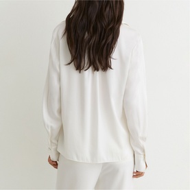 Model wearing Reiss white long-sleeve blouse, back view, paired with matching white trousers