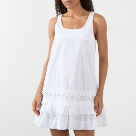 Model wearing Ganni Bright White cotton mini dress with tiered ruffle hem and square neckline, sleeveless fit