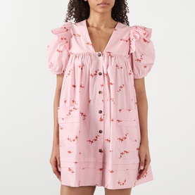 Model wearing Ganni Angel Floral Print Mini Dress in Silver Pink with frill shoulders, puff sleeves, V-neck, and button front fastening.