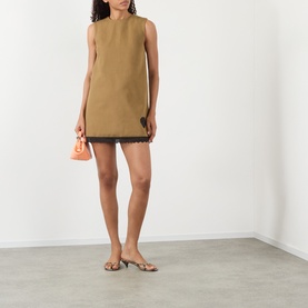 Model wearing Ganni Logo Patch Lace-Trim Mini Shift Dress in Ermine, sleeveless with lace hem, styled with flat sandals and mini bag.