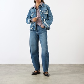 Model wearing Ganni Lace-Trim Denim Jacket in dark blue with lace detailing, styled with matching wide-leg jeans and black loafers.