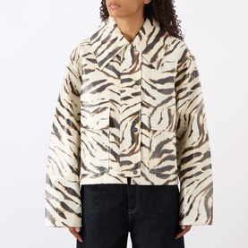Model wearing Ganni Zebra Print Laminated Denim Jacket in Egret, cropped length with point collar, flap pockets, styled with dark jeans.