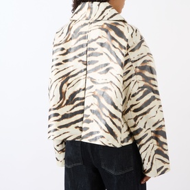 Model wearing Ganni Zebra Print Laminated Denim Jacket in Egret, showing rear view with dropped shoulders, styled with dark jeans.