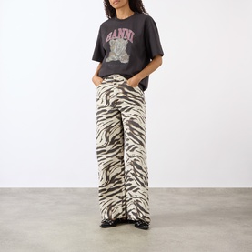 Model wearing Ganni Tiger Heavyweight Logo T-Shirt in Phantom with zebra-print wide-leg trousers and black loafers.