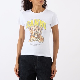 Model wearing Ganni Tiger Logo Baby Tee in Bright White with crew neck, tiger cub graphic print and yellow logo lettering, styled with dark jeans.