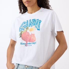 Model wearing Ganni Strawberry Logo T-Shirt in Bright White with crew neck, strawberry and daisy graphic print, styled with light blue jeans.
