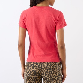Model wearing Ganni Cherry Logo Baby Tee in High Risk Red, short-sleeve cotton crew neck, styled with leopard-print trousers. Rear view.