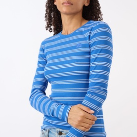 Model wearing Ganni Butterfly Logo Striped Long-Sleeved Top in Nouvean Navy, blue and white ribbed stripe, crew neck, styled with light-wash jeans.