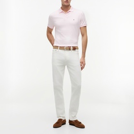 Model wearing Tommy Hilfiger Pink Lily polo shirt with white trousers, brown belt and brown suede loafers