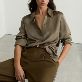 Model wearing Reiss khaki green satin shirt with matching wide-leg trousers and a tan leather belt.