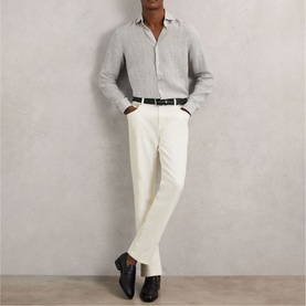 Model wearing Reiss white/thyme green shirt and cream trousers, styled with a black belt and black leather shoes