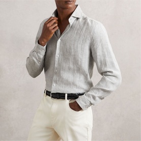 Model wearing Reiss white and thyme green striped linen shirt, styled with white trousers and black woven belt.